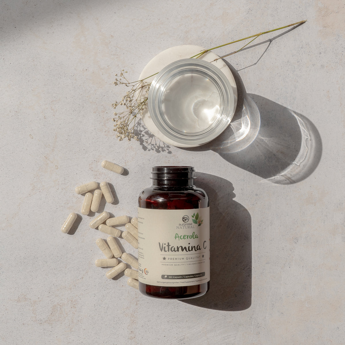 Cápsulas e frasco de Vitamina C Acerola Surpresa Natural com copo de água, suplemento para imunidade e energia