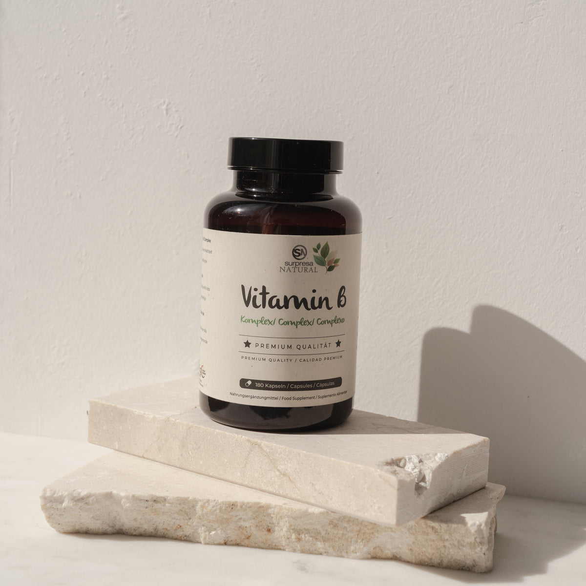 Frasco de Vitaminas B Complexo da Surpresa Natural sobre blocos claros